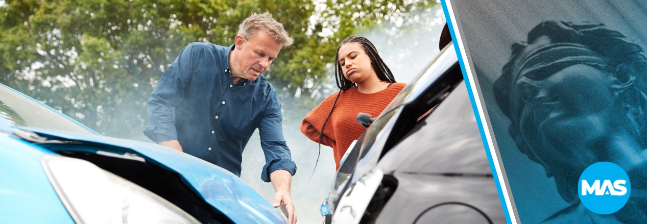 A man and a woman staring at a car accident.