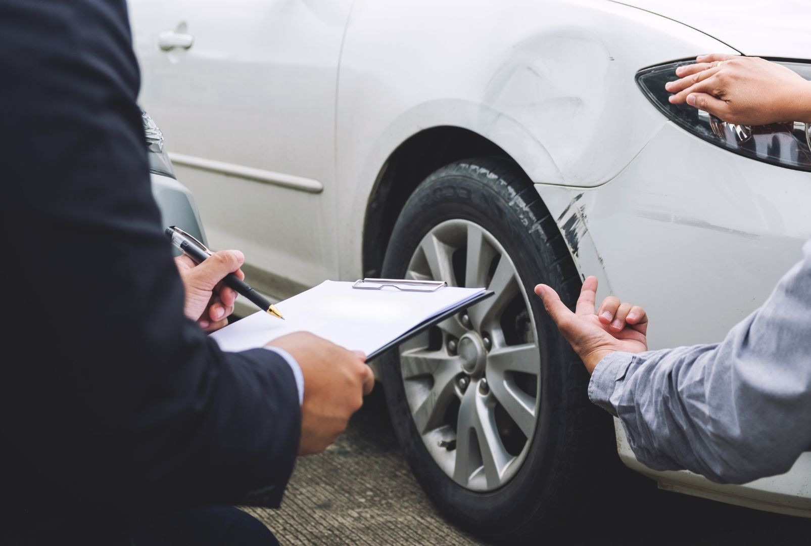 Insurance company talking with a driver after a car accident.